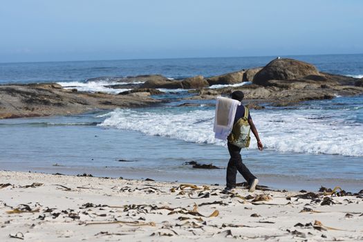 An African vendor selling painted artworks on a beach, Cape Town, South Africa