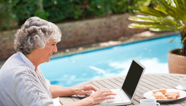 Mature woman working on her laptop outdoors