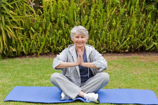 Retired woman practicing yoga in the garden