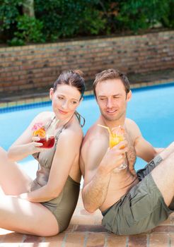 Couple drinking cocktails back-to-back outdoors