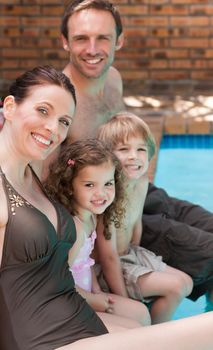 Happy family beside the swimming pool