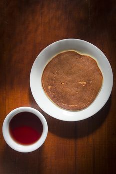 Pancake in a plate on a wooden table