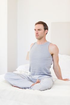 Man practicing yoga on his bed