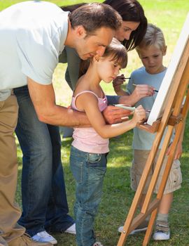 Family painting together in the park