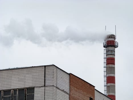 White smoke from an old factory chimney against the sky. Ecology. The concept of the environmental problem of air pollution. Copy space for text.