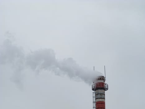 White smoke from an old factory chimney against the sky. Ecology. The concept of the environmental problem of air pollution. Copy space for text.