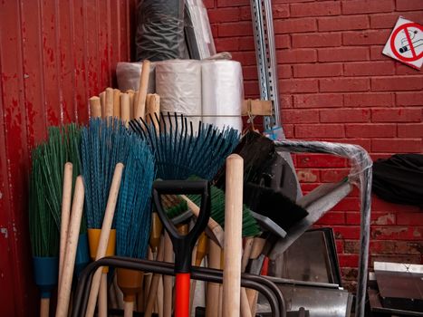 Many different tools for winter snow removal. Shovels of different shapes and brooms are in the corner. Household tool.