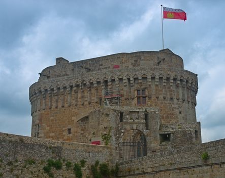 Big central stone tower with flag on top at Dinan fortress, France