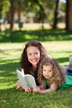 Woman with her daughter reading a book