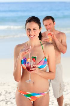 Couple drinking a cocktail on the beach