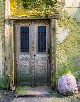 old antique wooden door in a wooden framework with a smooth stone wall outdoor architecture
