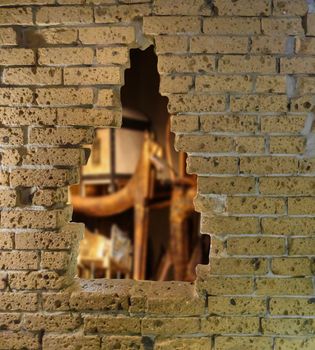 Yellow old brick wall in ruins with a big hole opening viewing on a egyptian treasure chamber archeology concept