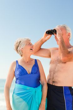 Elderly couple bird watching at the beach