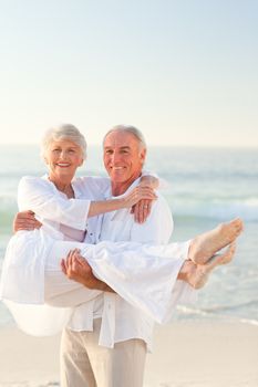 Man carrying his wife on the beach