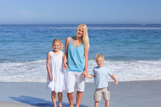 Joyful family walking on the beach