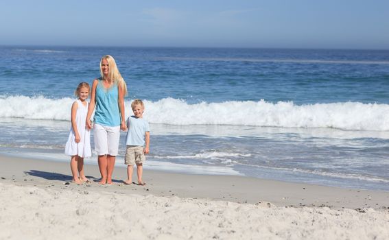 Joyful family walking on the beach