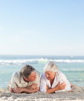 Mature couple lying down on the beach