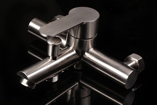 Water mixer on a black glass with reflection