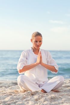 Peaceful woman practicing yoga against the sea