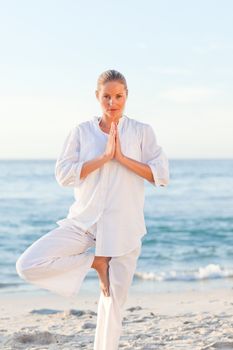 Active woman practicing yoga against the sea