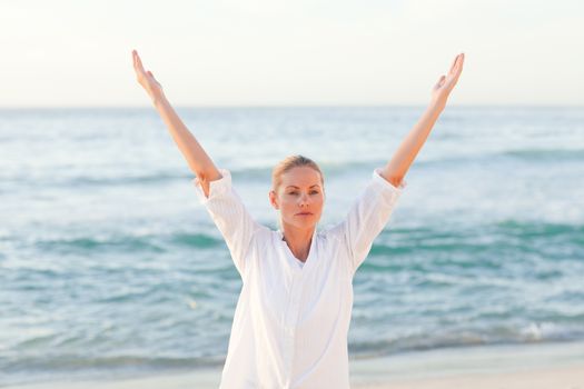 Active woman practicing yoga against the sea