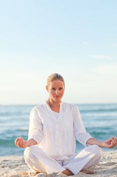 Active woman practicing yoga against the sea