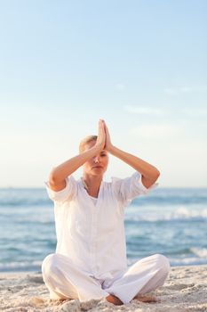 Active woman practicing yoga on the beach