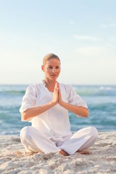 Peaceful woman practicing yoga against the sea