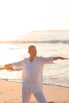 Peaceful woman practicing yoga on the beach