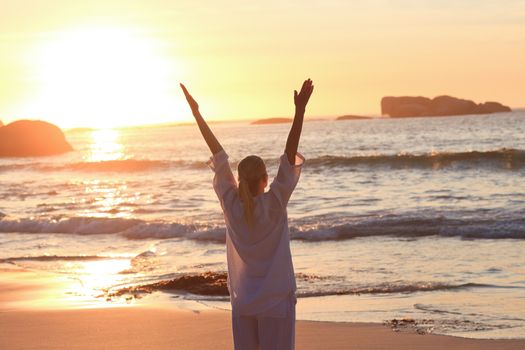 Woman practicing yoga during the sunset 