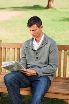 Handsome man making his crossword during the summer