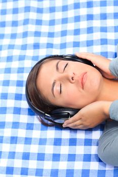 Woman listening to some music in the park during the summer