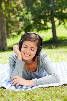 Woman listening to music in the park during the summer