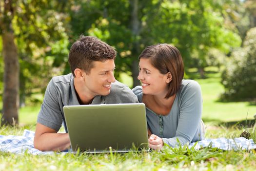 Lovers working on their laptop during the summer