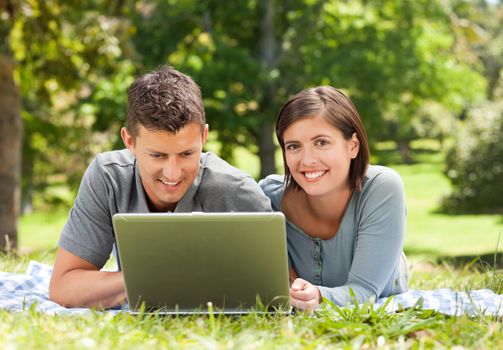 Lovers working on their laptop during the summer