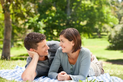 Couple lying down in the park during the summer