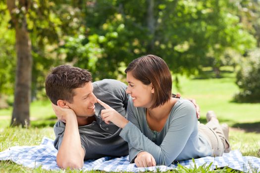 Couple lying down in the park during the summer