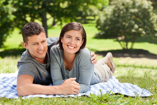 Couple lying down in the park during the summer