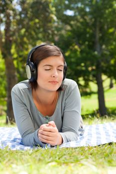 Woman listening to some music in the park during the summer