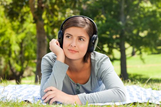 Woman listening to music in the park during the summer