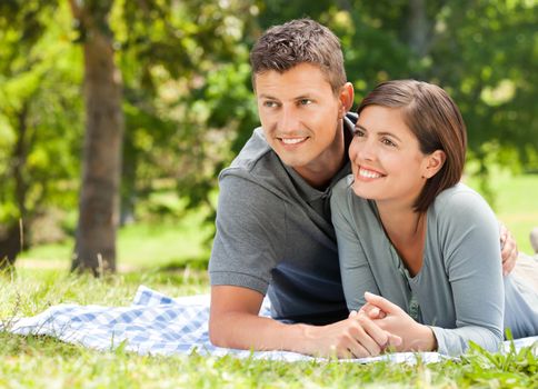 Couple lying down in the park during the summer