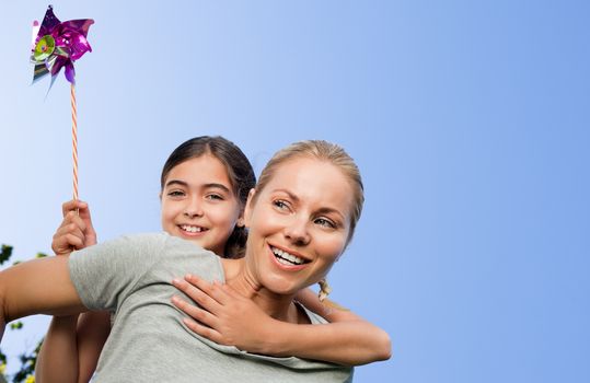 Mother and her daughter with a windmill during the summer