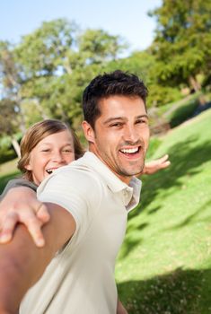 Father playing with his son in the park during the summer