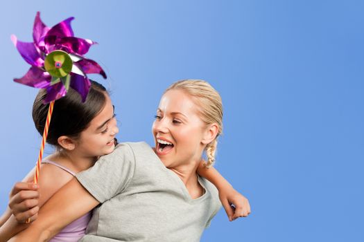 Mother and her daughter with a windmill during the summer