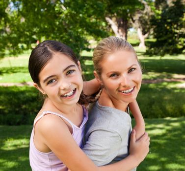 Mother and her daughter laughting in the park during the summer