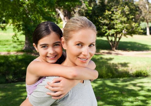 Mother and her daughter laughting in the park during the summer