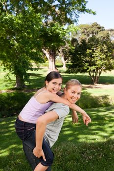 Daughter playing with her young mother during the summer