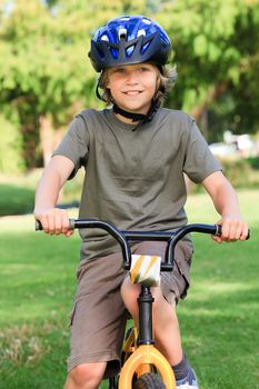 Little boy with his bike in a park during the summer