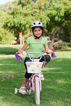 Little girl with her bike in a park