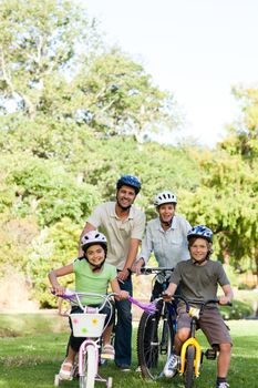 Family with their bikes during the summer in a park
